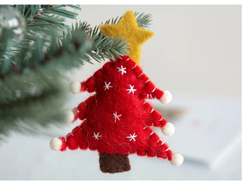Red felt Christmas tree ornament with white snowflakes and a yellow star on a branch.