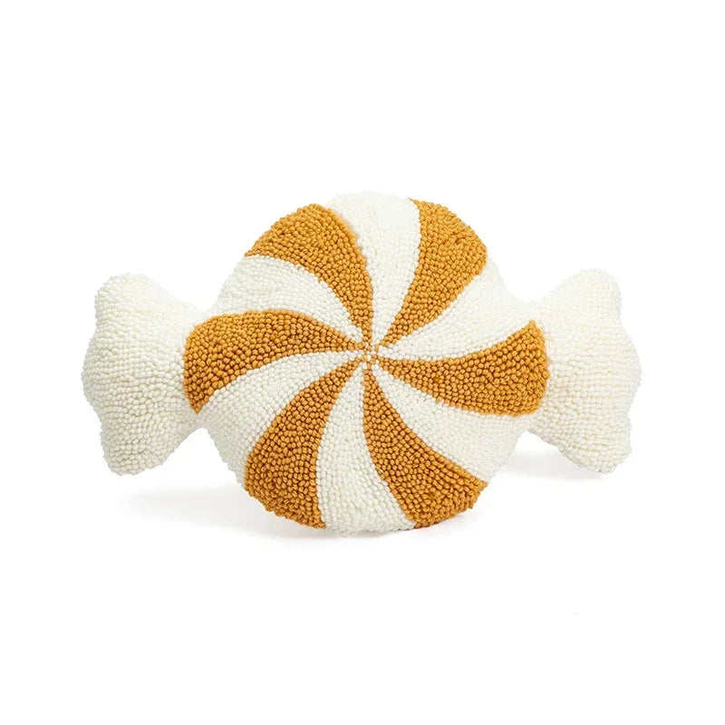 Decorative candy-shaped pillow with orange and white swirl pattern on a white background