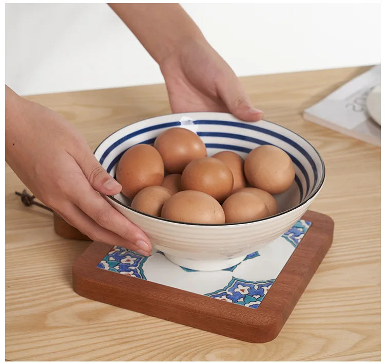 Bowl of eggs on a wooden surface with hands holding the bowl