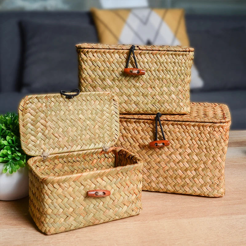 Set of woven baskets with handles on a wooden surface. Handmade seagrass rattan storage box with lid, rectangular woven organizer basket for makeup, jewelry, office, and boho home decor