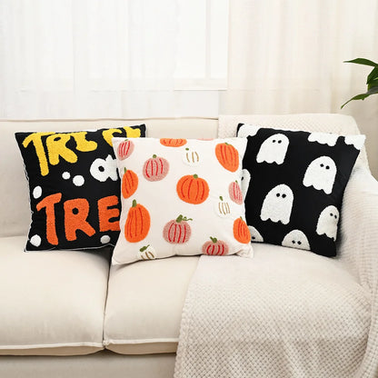 Three Halloween-themed pillows on a couch with pumpkins, ghosts, and 'Treat' text.