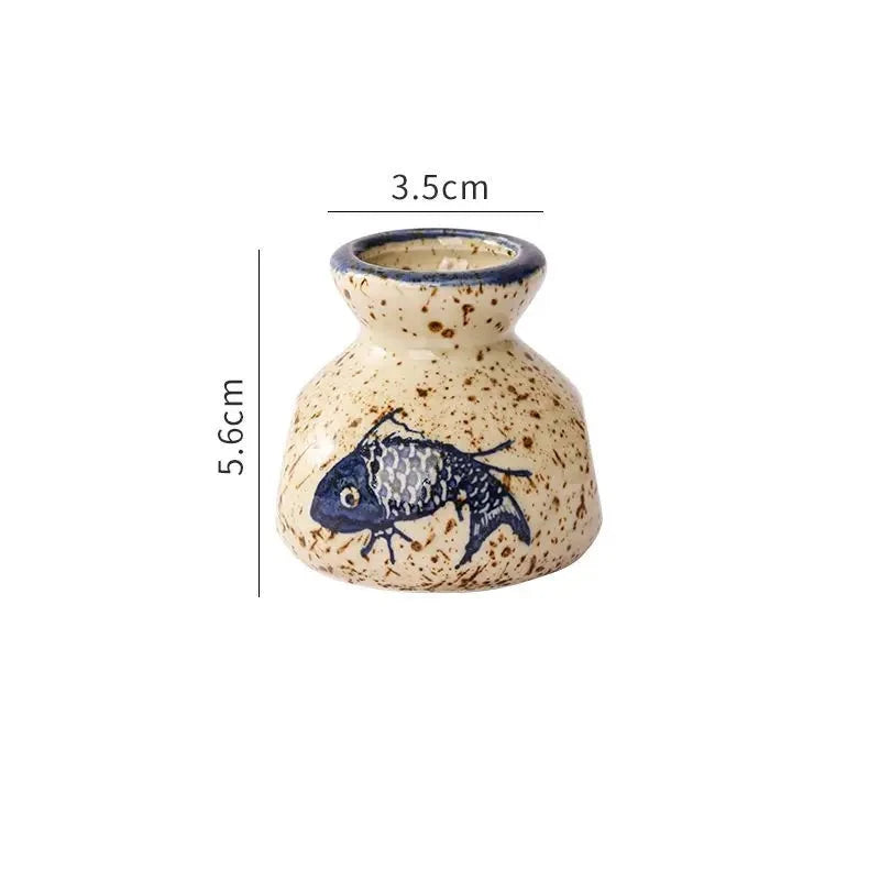 Small ceramic vase with fish design and measurements on a white background