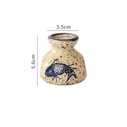 Small ceramic vase with fish design and measurements on a white background