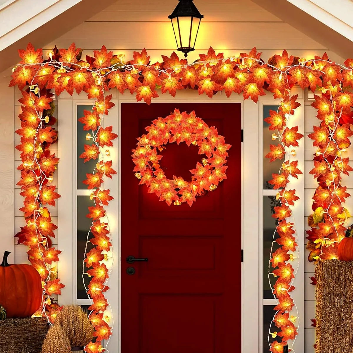 Decorative autumn garland with lights around a red door. fall leaf lights 