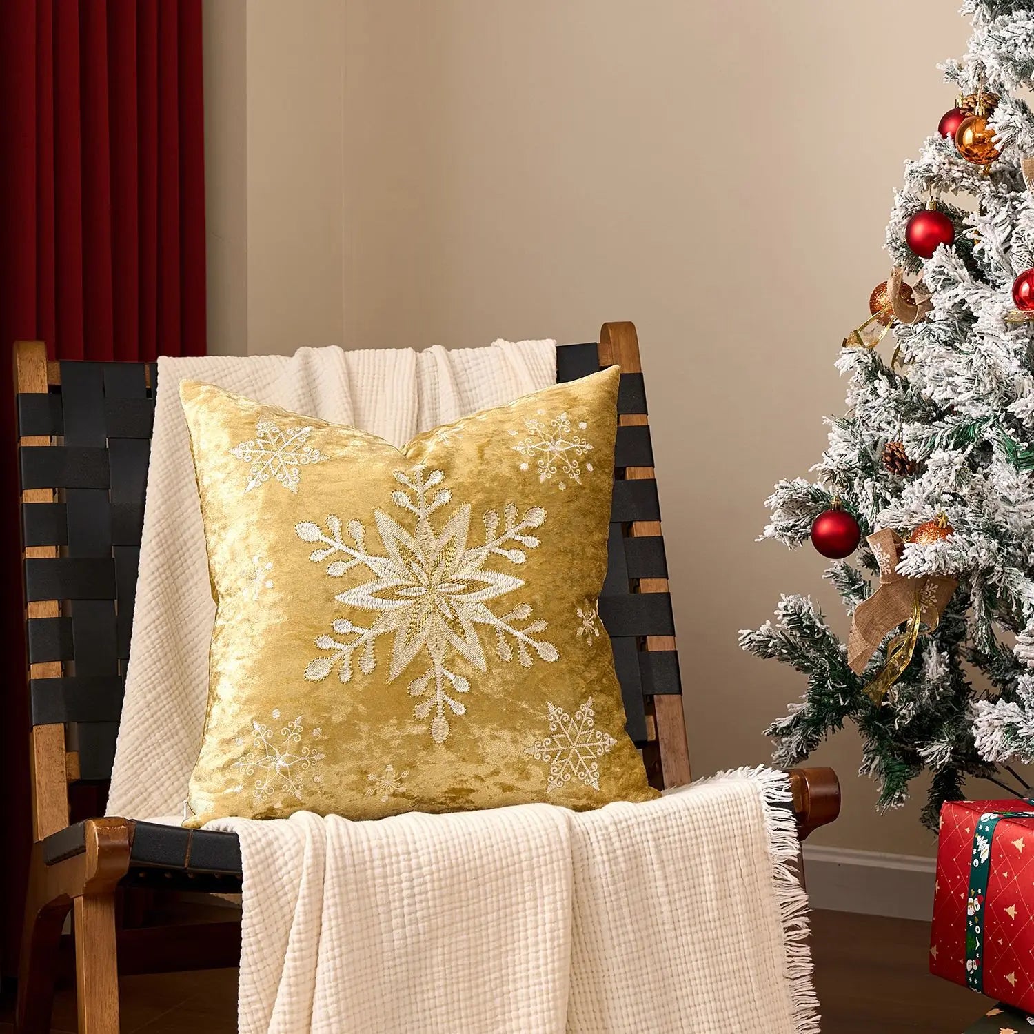 Yellow pillow with snowflake design on a chair next to a decorated Christmas tree. Embroidered Merry Christmas pillow cover with snowflake design – festive red and white holiday cushion for sofa or bedroom décor.