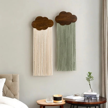 Two cloud-shaped wall art pieces on a light gray wall with a bed and side table in the foreground.