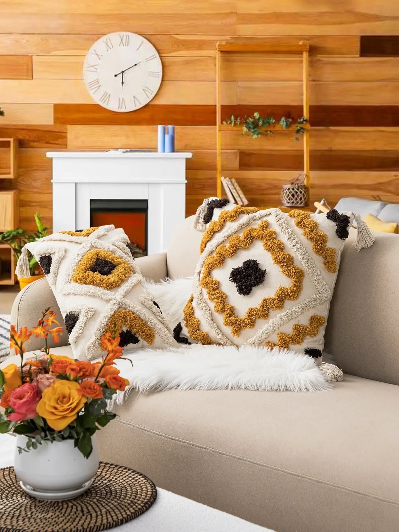 Decorative pillows on a couch with a fireplace and wooden wall in the background