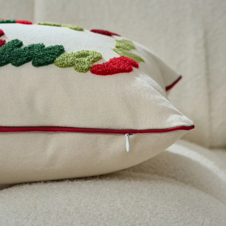 Decorative pillow with embroidered red flowers and green leaves on a beige background