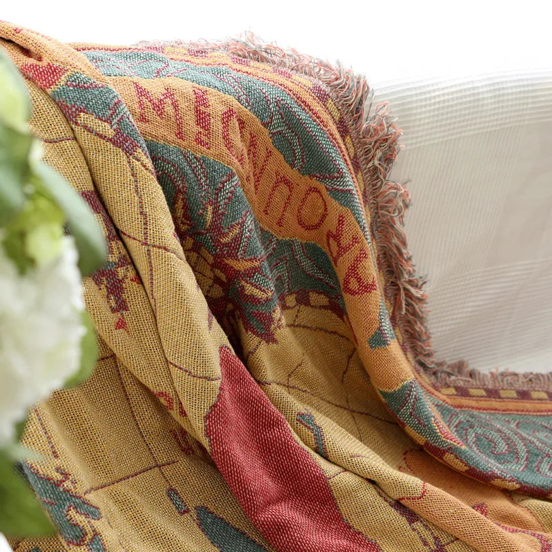 Colorful patterned blanket draped over a white surface. Bohemian world map woven blanket cotton sofa throw home decor