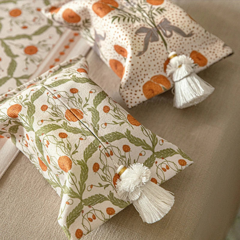 Decorative pillows with floral patterns and tassels on a neutral surface boho home decor, reusable tissue bag, cotton tassel tissue holder, plush tissue organizer, bathroom tissue box cover, car tissue case, American style tissue pouch, soft fabric tissue holder, decorative tissue box, housewarming gift, eco-friendly storage
