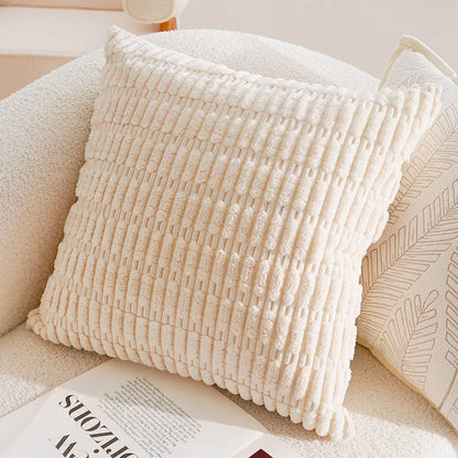 Textured beige pillow on a couch with a magazine underneath