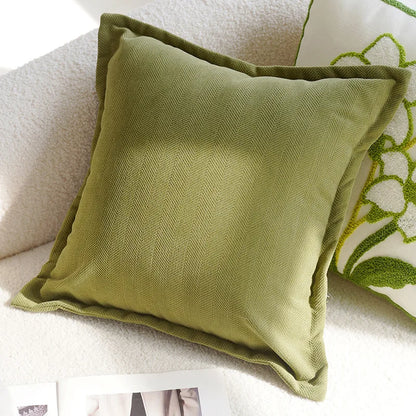 Green pillow on a sofa with a floral patterned pillow in the background Nordic lily embroidered throw pillow cover in flannel fabric, floral square cushion case for sofa, bed, and boho home decor