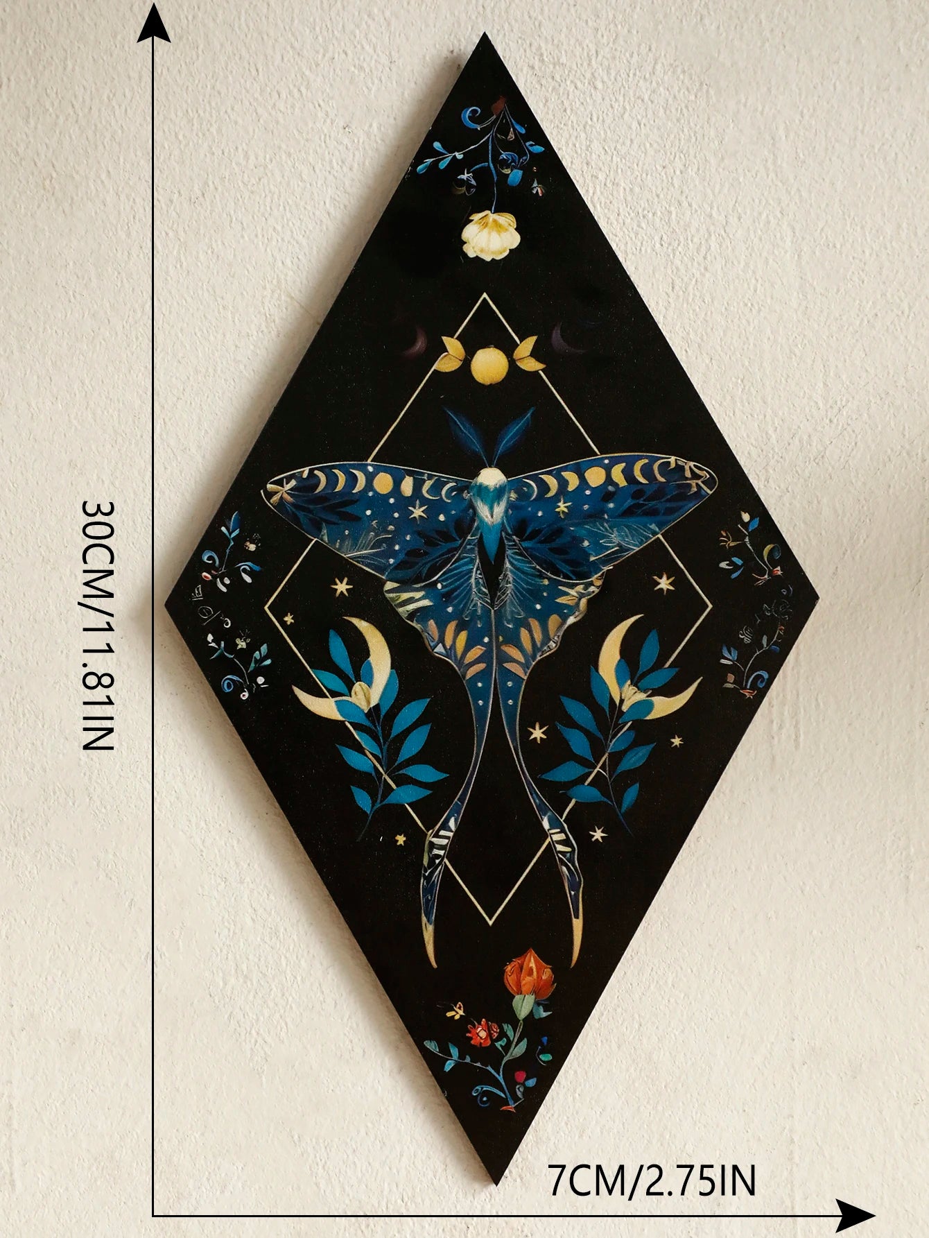 Decorative wall art with a blue moth design on a black background, shown with measurements. Rustic colorful wood wall art panel with moon, stars, and butterfly engraving, displayed above a sofa in a boho-styled living room