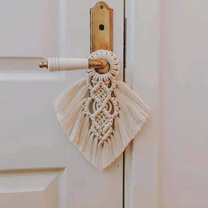 Macrame door handle cover with tassels attached to a door handle.