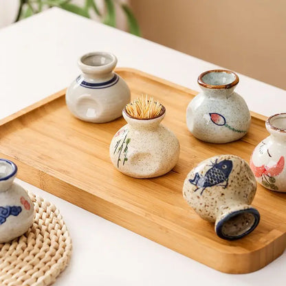 Set of small ceramic containers on a wooden tray with a blurred background