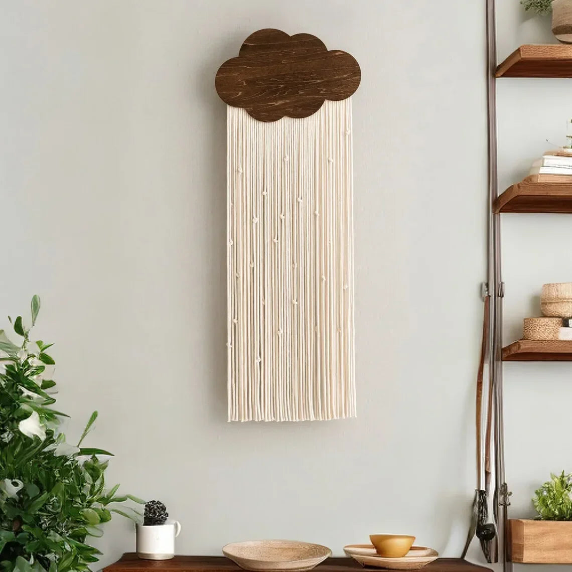 Decorative wall hanging with wooden cloud design on a light gray wall.