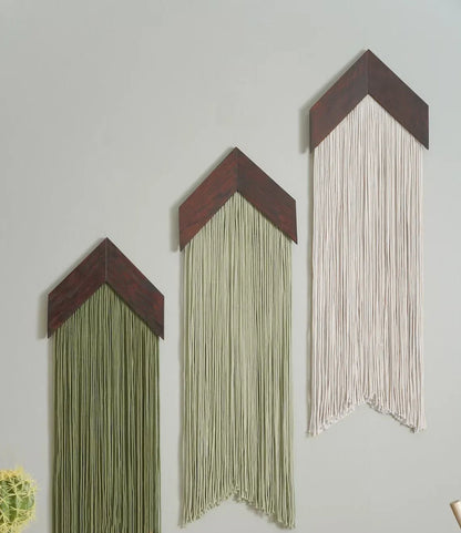 Three wall art pieces with chevron designs and string decorations on a light gray background.