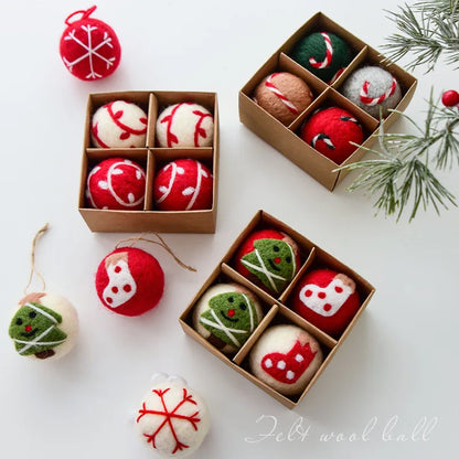 Felt wool ball ornaments in small cardboard boxes on a white surface with Christmas decorations.