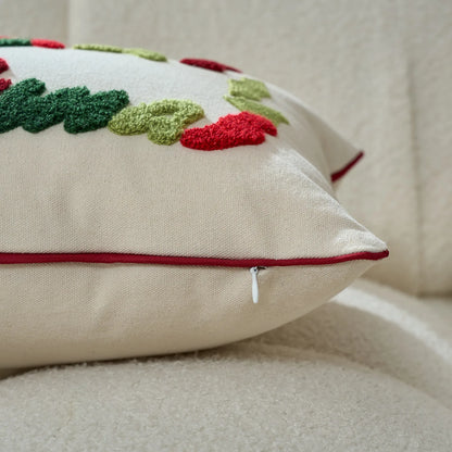 Decorative pillow with embroidered red and green leaves on a beige background