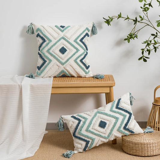 Decorative pillows with geometric patterns on a wooden bench and stool.
