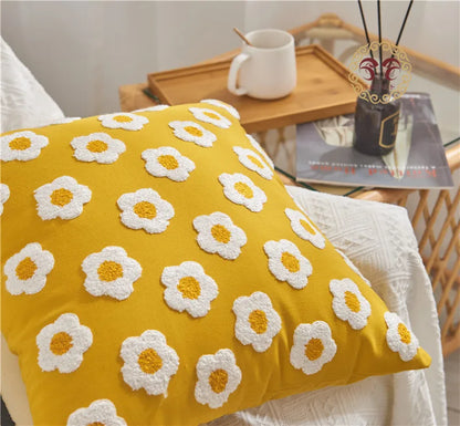 Yellow pillow with white flower patterns on a couch