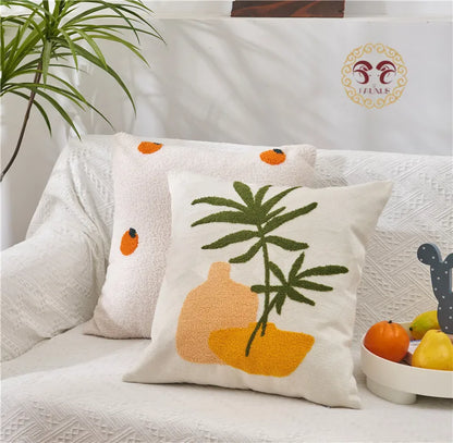 Decorative pillows with fruit and plant designs on a couch, featuring the brand 'Fable'.