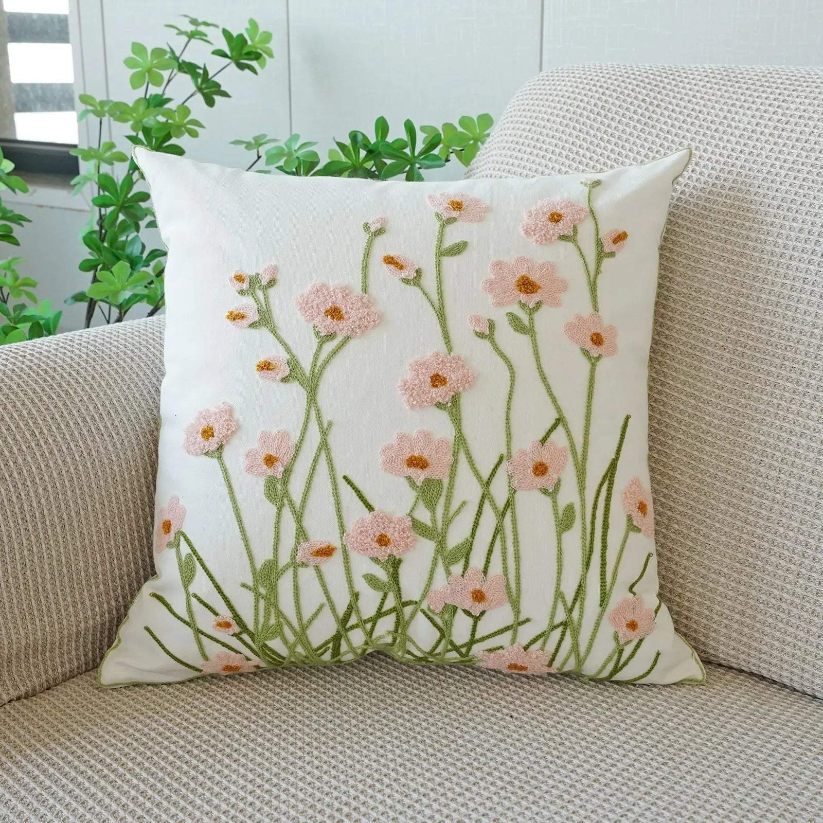 Floral-patterned pillow on a beige couch with plants in the background. Floral embroidered throw pillow cover boho decor