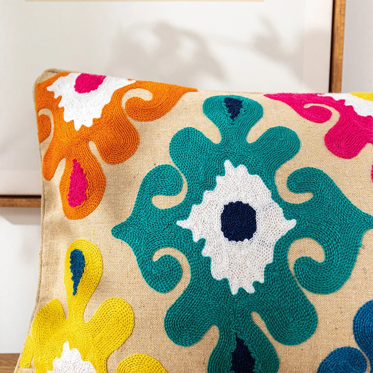 Decorative pillow with colorful abstract pattern on a beige background. Bohemian embroidered throw pillow cover with geometric design, cotton-blend cushion for sofa, bed, or modern home decor.