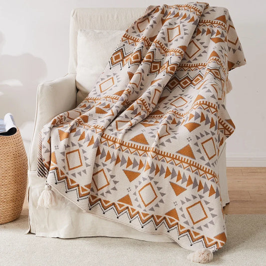 Bohemian Patterned blanket draped over a chair in a room with a woven basket and wooden floor.