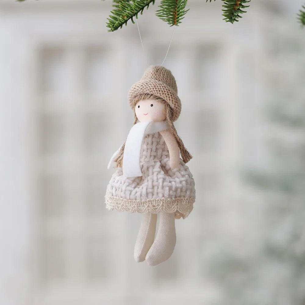 Decorative angel figurine with a knitted hat and dress hanging against a blurred natural background.
