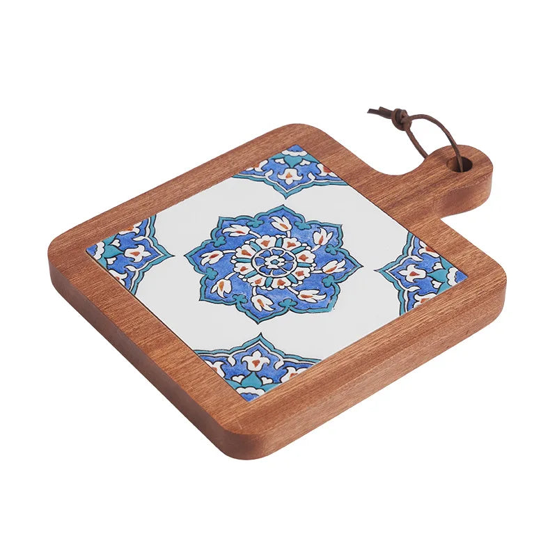 Wooden cutting board with decorative tile design on a white background