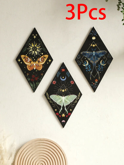 Three decorative wall art pieces with celestial designs on a light background. Rustic colorful wood wall art panel with moon, stars, and butterfly engraving, displayed above a sofa in a boho-styled living room