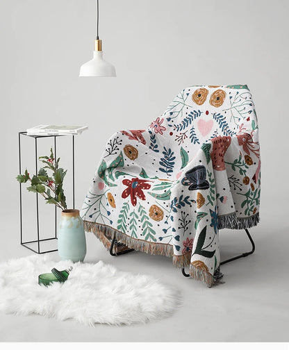 Floral-patterned blanket draped over a chair with a white background. Deer forest jacquard woven blanket with floral and woodland tapestry design – boho throw for sofa or bed, soft cotton blend decorative bedspread for cozy home décor.