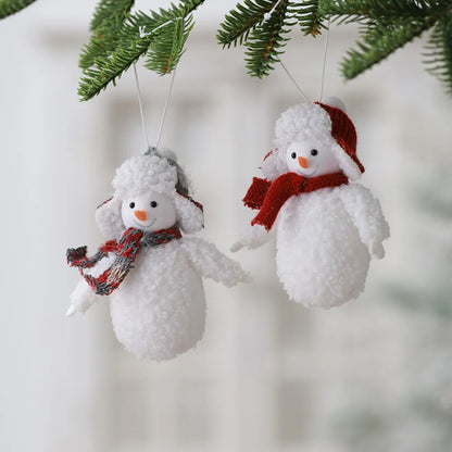 Two snowman ornaments hanging from a Christmas tree.
