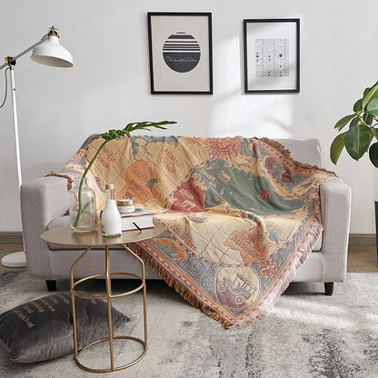 Decorative blanket with world map design draped over a sofa in a living room. Bohemian world map woven blanket cotton sofa throw home decor