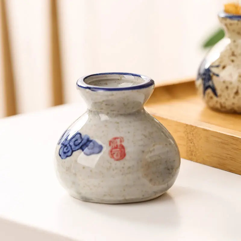 Ceramic bottle with blue and red design on a white surface