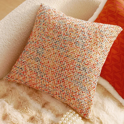 Textured pillow with orange and beige pattern on a soft surface. Boho Home Decor. 
