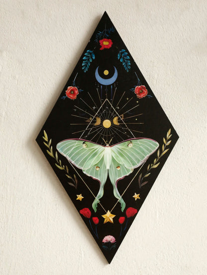 Decorative wall art with a green butterfly, flowers, and celestial elements on a black background. Rustic colorful wood wall art panel with moon, stars, and butterfly engraving, displayed above a sofa in a boho-styled living room