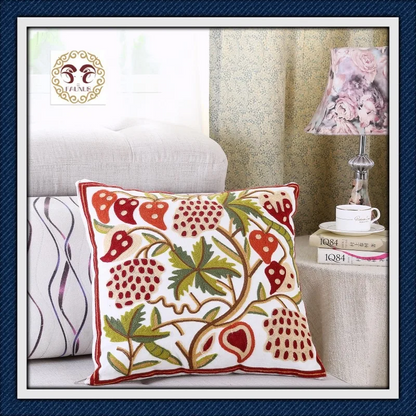 Decorative pillow with floral pattern on a sofa next to a lamp and books.